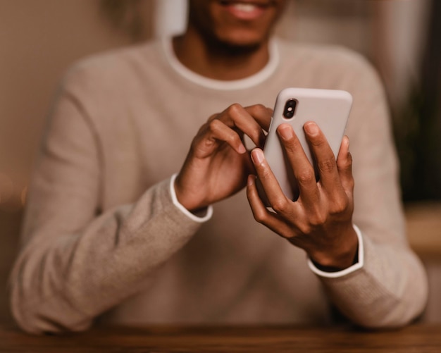 Foto vista frontal do homem usando seu smartphone em casa