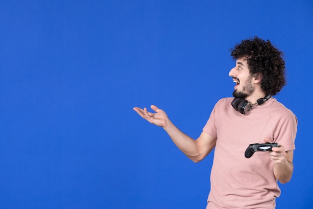 vista frontal do jogador masculino com gamepad no fundo azul adolescente jogador adulto futebol alegria jovem virtual jovem sofá