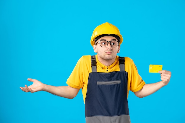 Vista frontal do trabalhador masculino em uniforme amarelo com cartão de crédito em azul