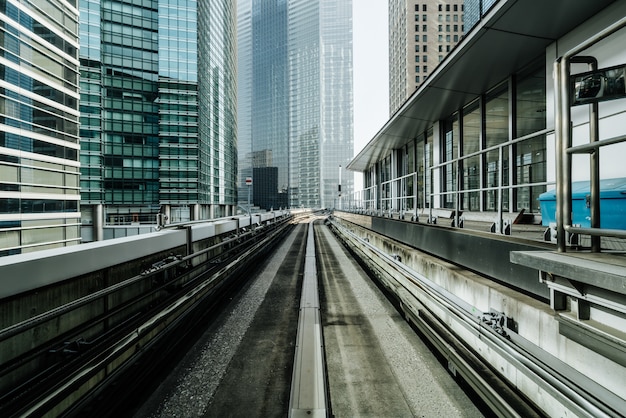 Vista frontal do trem na cidade moderna. Trilho reto com fundo de edifícios da cidade.