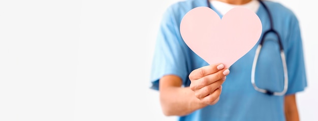 Foto vista frontal de la doctora desenfocada con corazón de papel