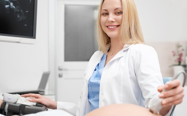 Foto vista frontal de la doctora haciendo procedimiento de ultrasonido