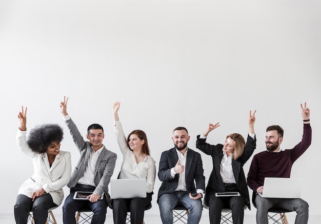 Vista frontal de empresarios con las manos arriba