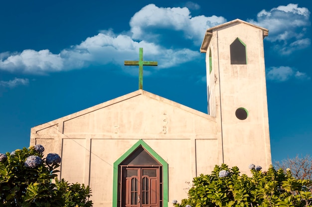 Foto vista frontal de la entrada de una iglesia, vista de la entrada de una iglesia con la cruz en el techo