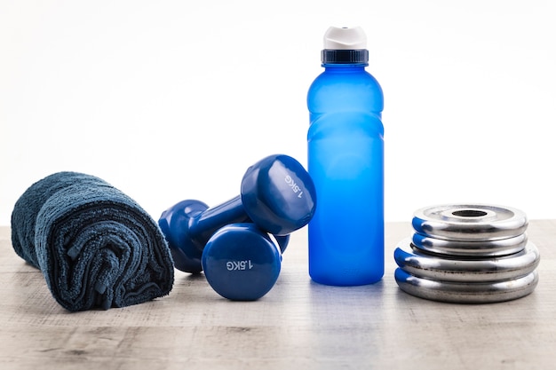 Vista frontal del equipo de gimnasio con agua y una toalla al lado