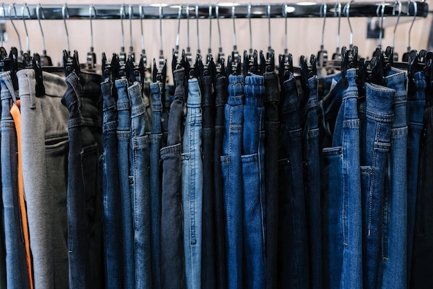 Vista frontal del estante con jeans en una tienda de ropa diferentes jeans en un hambre