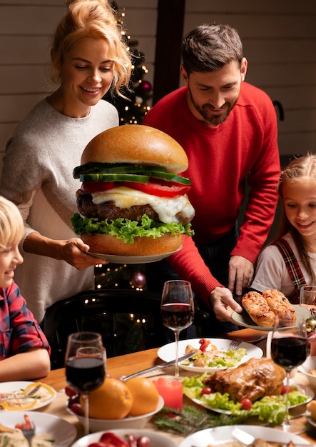 Vista frontal familia feliz con comida gigante