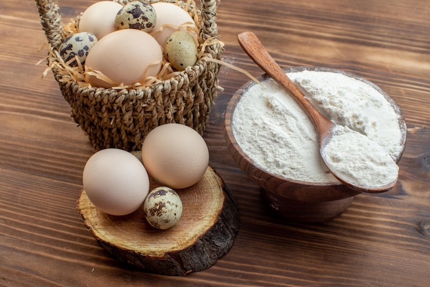 vista frontal farinha branca com ovos em marrom mesa de madeira refeição torta bolo forno assar massa cozinhar biscoito