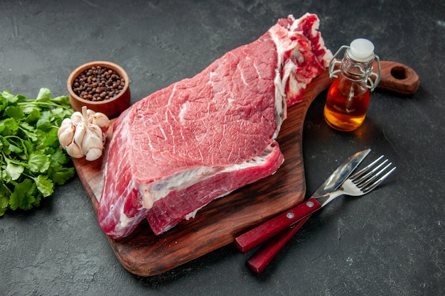 Vista frontal fatia de carne crua com verduras e temperos em fundo escuro cor de cozinhar comida carne churrasco refeição açougueiro