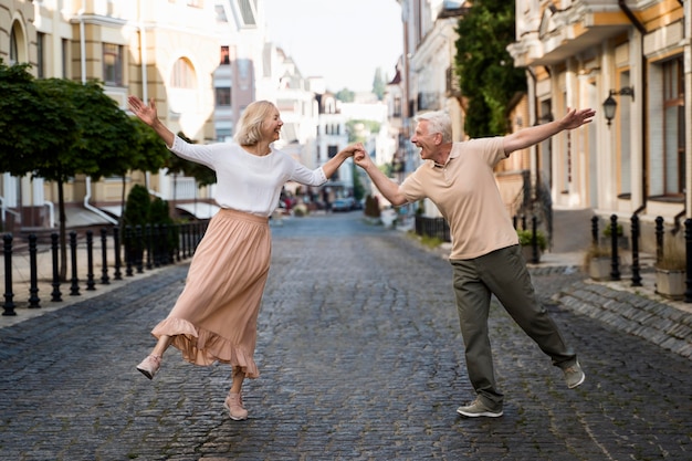 Vista frontal de la feliz pareja de ancianos en la ciudad