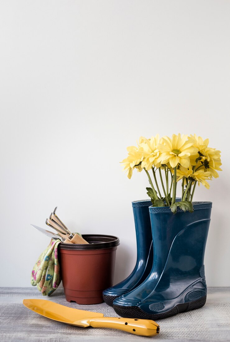 Foto vista frontal flores em botas e ferramentas de jardinagem