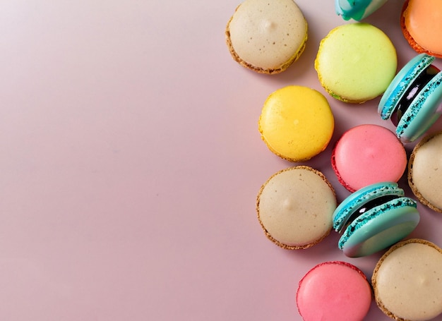 Una vista frontal galletas rosas deliciosas y sabrosas junto con dulces de colores y espacio de copia