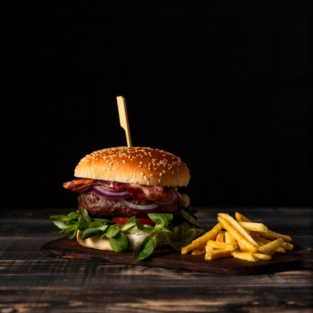 Foto vista frontal de hamburguesas y papas fritas en la mesa