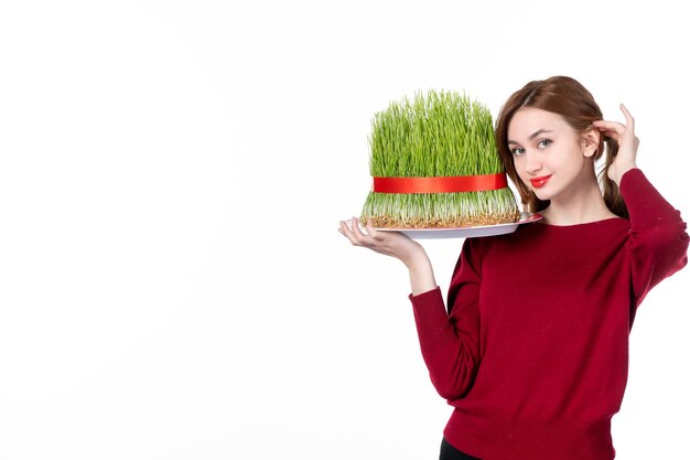 Vista frontal hembra joven sosteniendo gran semeni novruz sobre fondo blanco etnia familia artistas intérpretes o ejecutantes colores concepto primavera vacaciones étnico