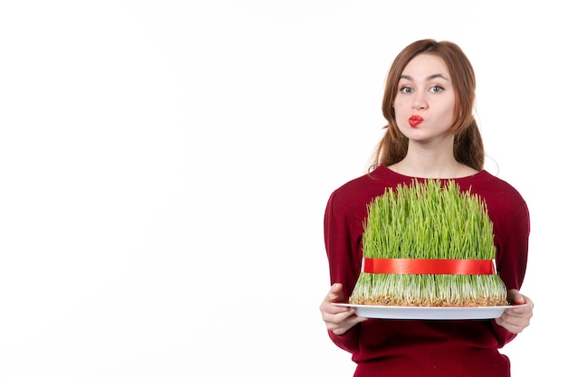 Vista frontal de las hembras jóvenes sosteniendo grandes novruz semeni sobre fondo blanco etnia familia étnica concepto de vacaciones color de ejecutante de primavera