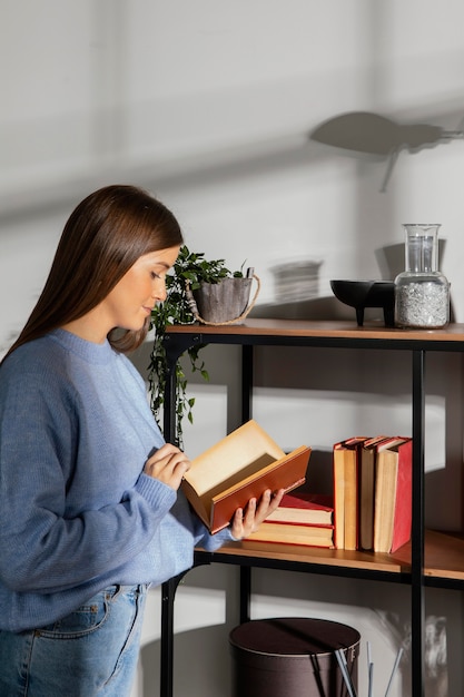 Vista frontal de la hermosa mujer leyendo un libro