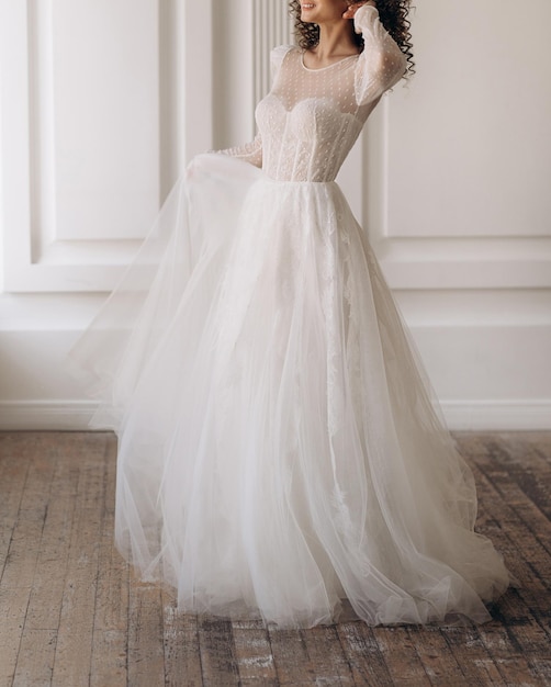 Vista frontal de la hermosa novia con un vestido blanco hermoso vestido de novia con elegantes mangas elegantes