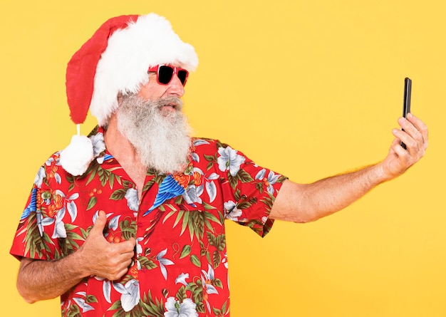 Vista frontal del hombre con camisa tropical y sombrero de navidad