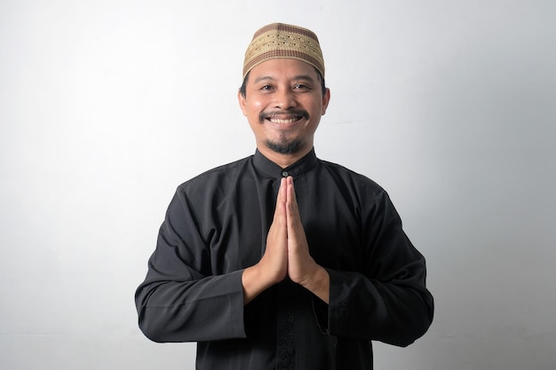 Vista frontal del hombre musulmán asiático feliz con gesto de mano de saludo