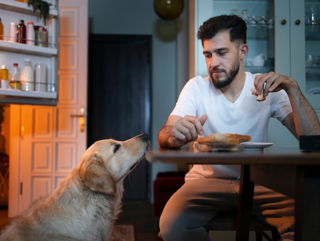 Vista frontal hombre con perro en la cocina