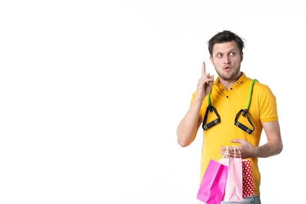 Vista frontal de los hombres jóvenes con expansor sosteniendo paquetes de regalo sobre fondo blanco trabajo color deporte vendedor trabajador uniforme de compras