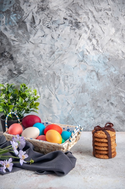 Vista frontal de los huevos de pascua de colores con un bonito cuadro diseñado en la superficie blanca concepto de grupo multiétnico colores primavera ornamentada