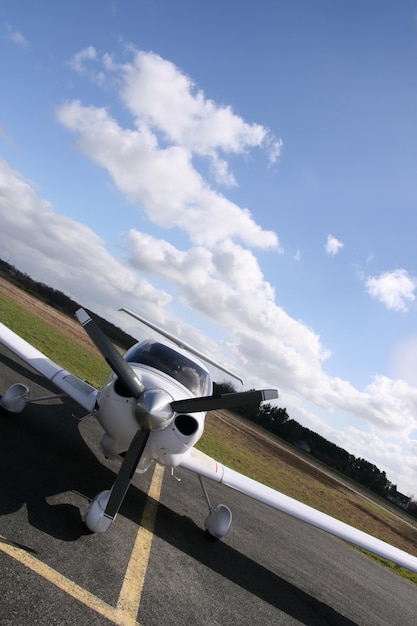 Vista frontal inclinada de um avião branco na pista