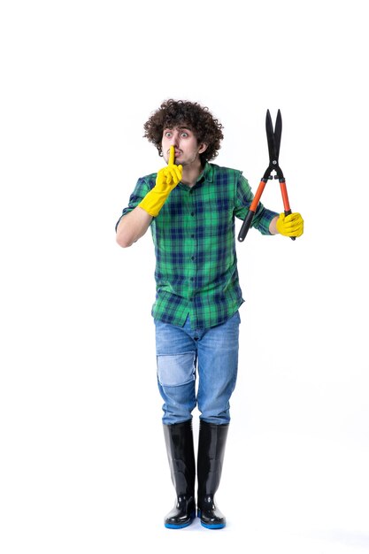 Foto vista frontal jardineiro masculino segurando tesouras de jardim no fundo branco terreno campo árvore flores trabalho com água grama jardim cortar folha