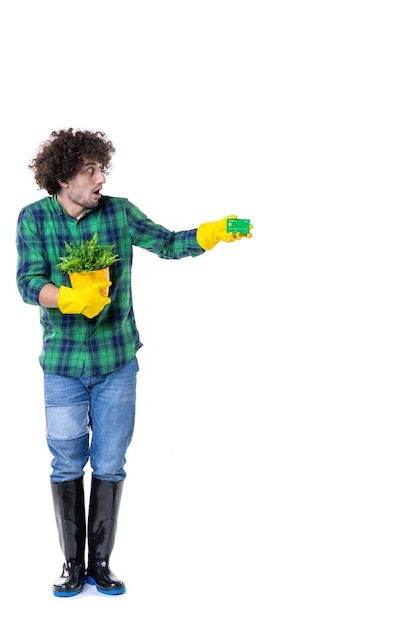 vista frontal jardineiro masculino segurando uma pequena planta e um cartão bancário no fundo branco terreno campo árvore escavação flor grama folha jardim água trabalho