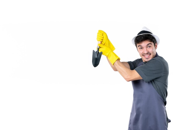 Vista frontal jardinero masculino en guantes amarillos con pequeña espátula sobre fondo blanco árbol flor jardín trabajo de tierra arbusto trabajo de hierba