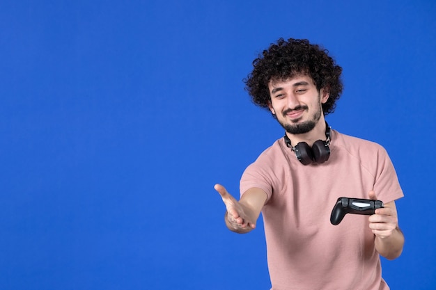 vista frontal jogador masculino com gamepad apertando as mãos no fundo azul futebol adulto alegria sofá jogador jovem jovem vencendo adolescente virtual