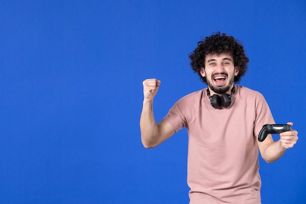 vista frontal jogador masculino com gamepad no fundo azul jogador adulto jovem adolescente vencedor de futebol virtual