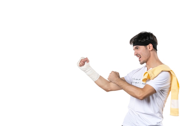 vista frontal jovem do sexo masculino com bandagem na mão machucada no fundo branco atleta ginásio dieta esporte dor lesão hospital corpo ajuste estilo de vida