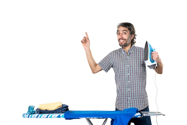 vista frontal jovem do sexo masculino segurando o ferro no fundo branco tarefas domésticas, engomar, cor, máquina, roupas limpas, casa