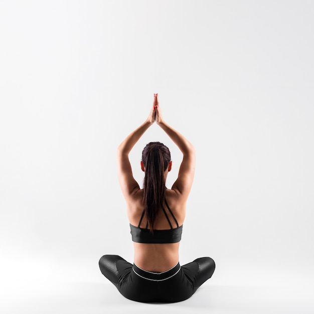 Foto vista frontal jovem fêmea em pose de ioga
