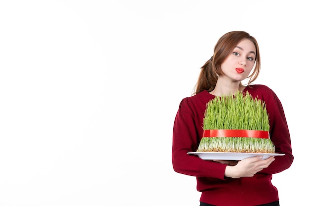 Foto vista frontal jovem fêmea segurando grande novruz semeni no fundo branco etnia família étnica feriados conceito primavera artista cores