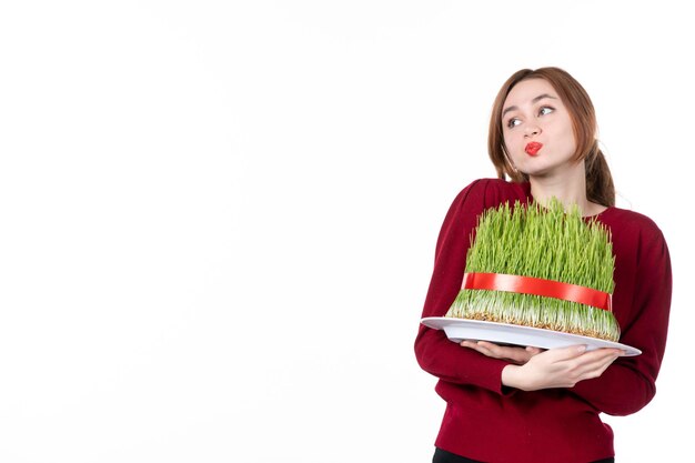 vista frontal jovem fêmea segurando grande novruz semeni no fundo branco etnia família étnica férias conceito primavera artista cores