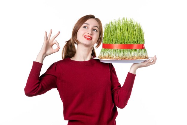 vista frontal jovem fêmea segurando grande novruz semeni no fundo branco família primavera étnica artistas cores etnia conceito férias