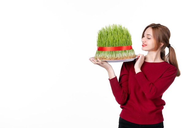 vista frontal jovem fêmea segurando grande novruz semeni no fundo branco família primavera intérprete cores etnia conceito férias