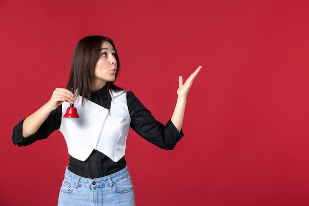 vista frontal jovem garçonete de uniforme segurando sininho no fundo vermelho mulher jantar trabalho noite beleza trabalho trabalhador