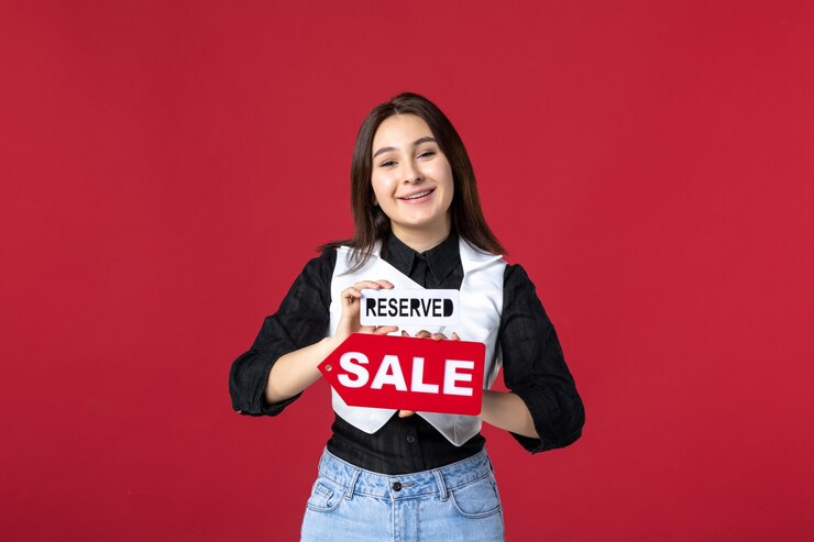 Foto vista frontal jovem garçonete segurando vendas e reservadas placas de identificação escritas em fundo vermelho uniforme cor trabalho mulher trabalho jantar refeição beleza comida noite