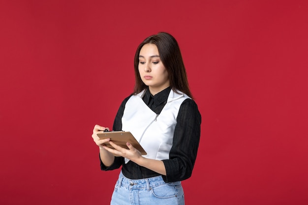 vista frontal jovem garçonete uniformemente escrita ordem no fundo vermelho beleza mulher jantar trabalho noite trabalho restaurante trabalhadores