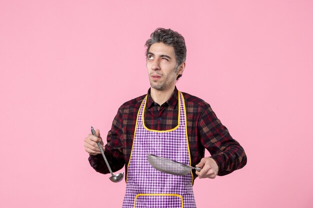 vista frontal jovem macho na capa com peneira e colher no fundo rosa trabalhador uniforme comida cozinheiro cozinha horizontal cozinha sopa profissão