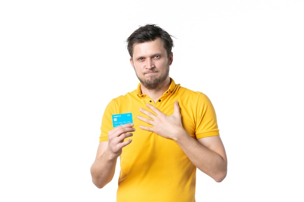 vista frontal jovem macho segurando cartão de banco verde sobre fundo branco ginásio trabalho vendedor uniforme dinheiro compras saúde esporte