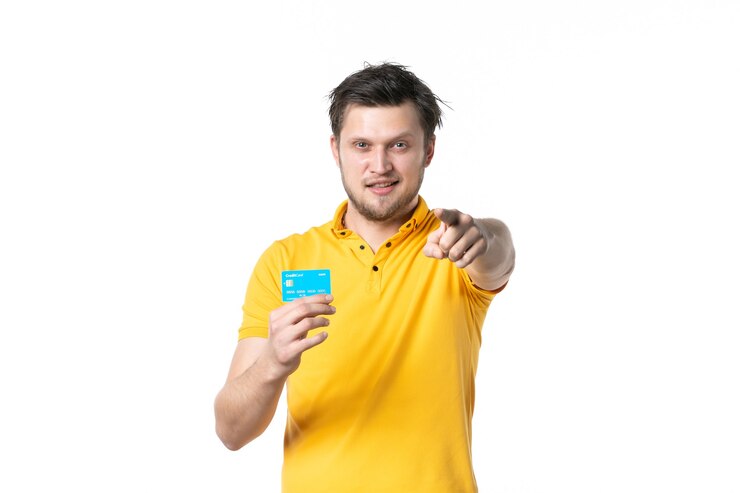 Foto vista frontal jovem masculino segurando um cartão de banco verde sobre fundo branco ginásio trabalho esporte vendedor uniforme compras saúde