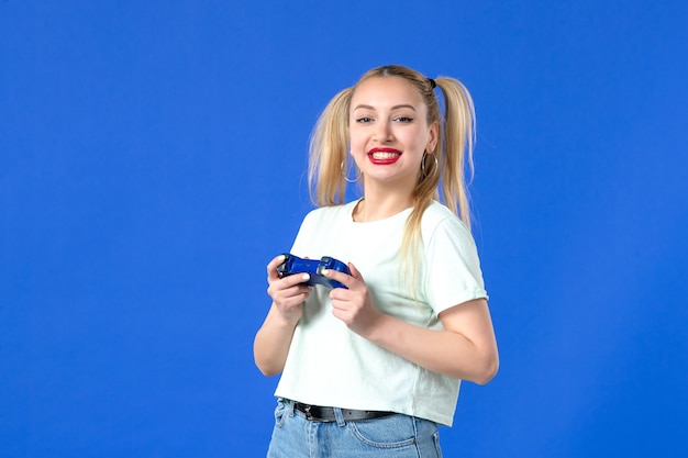 vista frontal jovem mulher com gamepad no fundo azul jovem joystick adulto alegre jogador vencedor online vídeo virtual