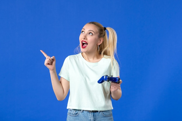 vista frontal jovem mulher com gamepad no fundo azul jovem joystick de vídeo online alegre jogador adulto vencedor