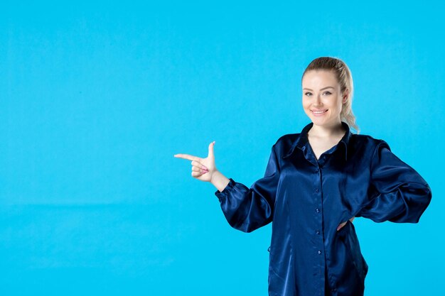 vista frontal jovem mulher de pijama em fundo azul noite sono cama festa descanso bocejo sorriso sonho pesadelo mulher cansada