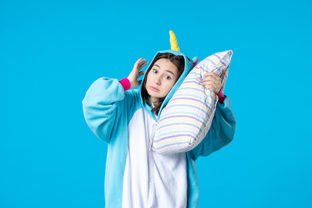 vista frontal jovem mulher em festa de pijama segurando travesseiro sobre fundo azul cama de sonho tarde pesadelo mulher divertido jogo noturno de sono