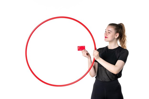 Foto vista frontal jovem mulher segurando bambolê e cartão do banco na mesa branca ioga corpo estilo de vida esporte saúde atleta circo dinheiro ginásio